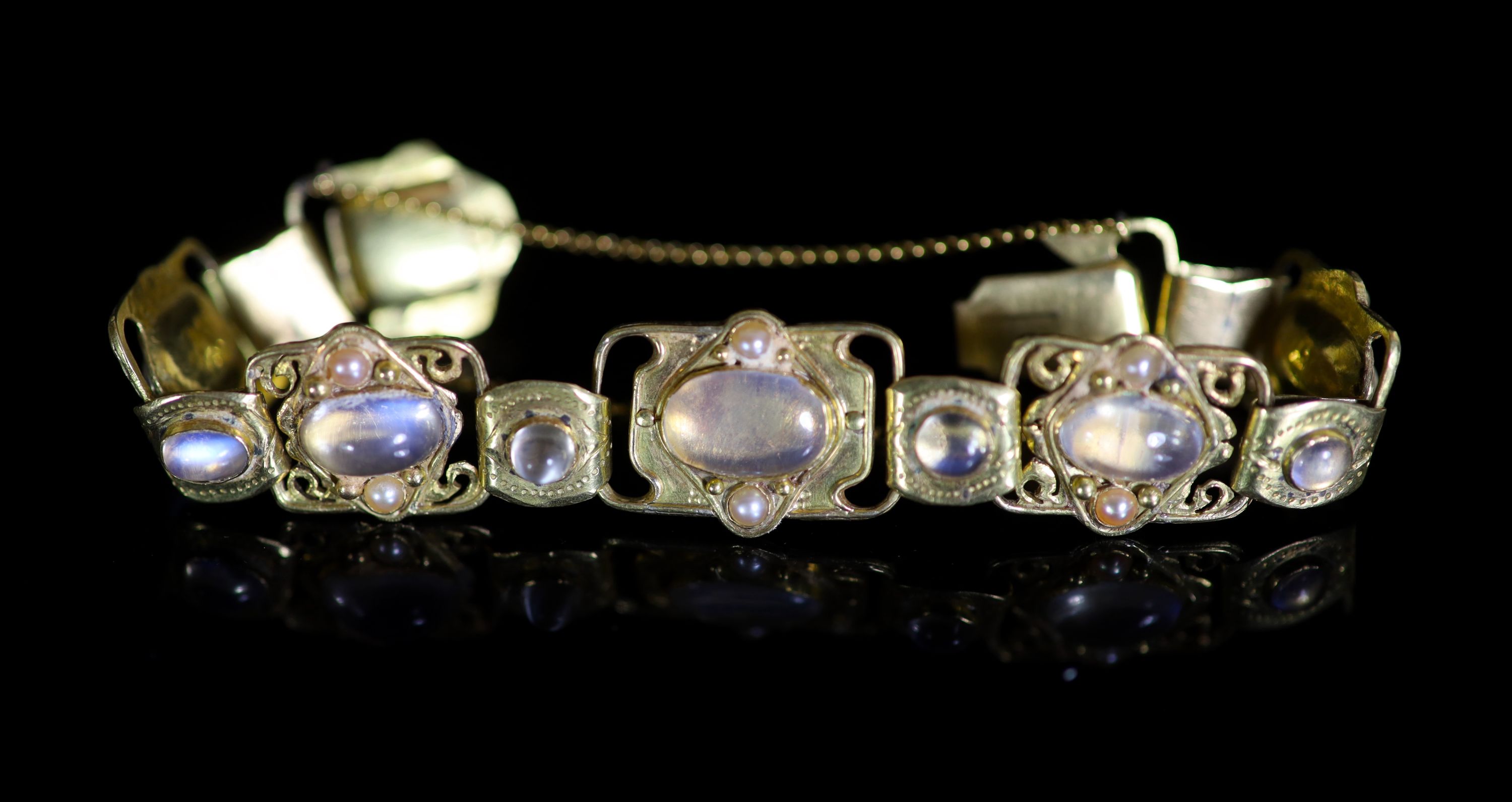 An early 20th century Arts & Crafts gold, cabochon moonstone and split pearl set bracelet